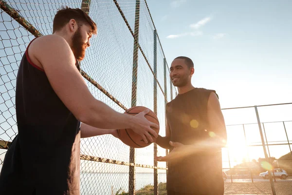 Pria muda olahraga memberikan basket kepada temannya — Stok Foto
