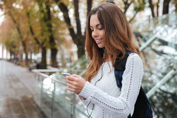 Boldog asszony hallgató-hoz zene-a smartphone-ban park — Stock Fotó