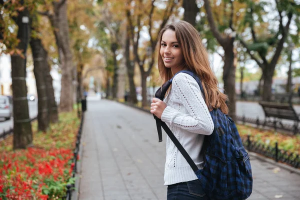 Веселая привлекательная молодая женщина с рюкзаком прогулки в парке — стоковое фото