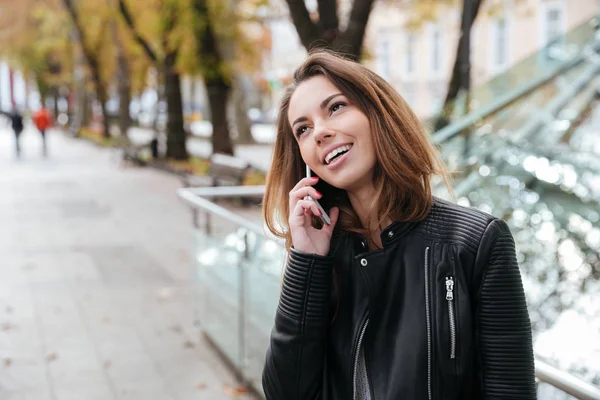 Ayakta ve şehrin cep telefonuyla konuşan kadın — Stok fotoğraf