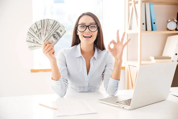 Geschäftsfrau hält Geld in der Hand und macht Okay-Geste — Stockfoto