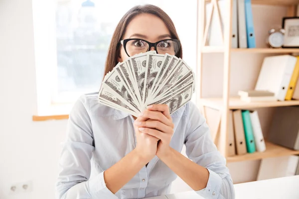 Zakenvrouw aanhouden van geld in de hand in de buurt van gezicht — Stockfoto