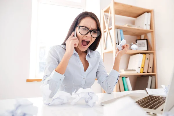 Confused businesswoman screaming while talking by phone — Stock Photo, Image