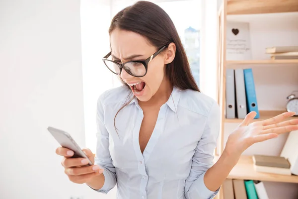 Femme d'affaires criant tout en regardant le téléphone — Photo