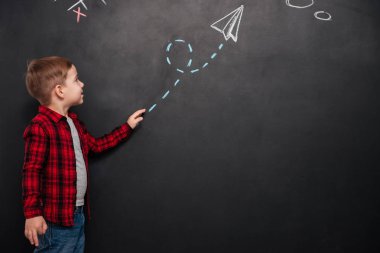 Kara tahta ve işaret eden ok bakarak küçük çocuk