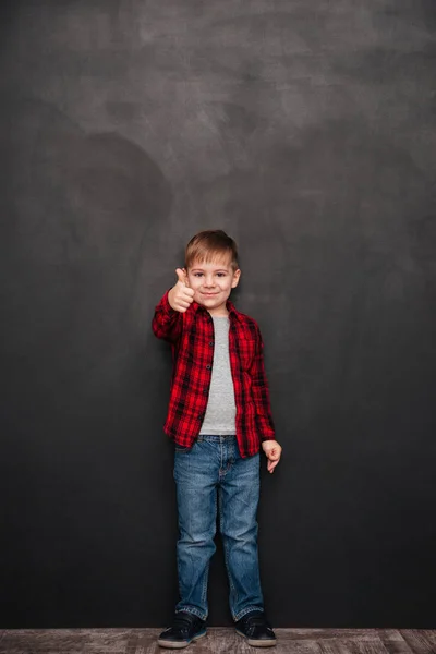 Jongen boven schoolbord staan en duimen omhoog gebaar maken — Stockfoto