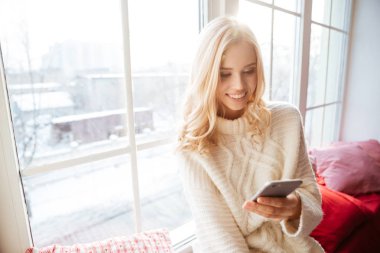 Kazaklı pencerenin yakınındaki genç kız