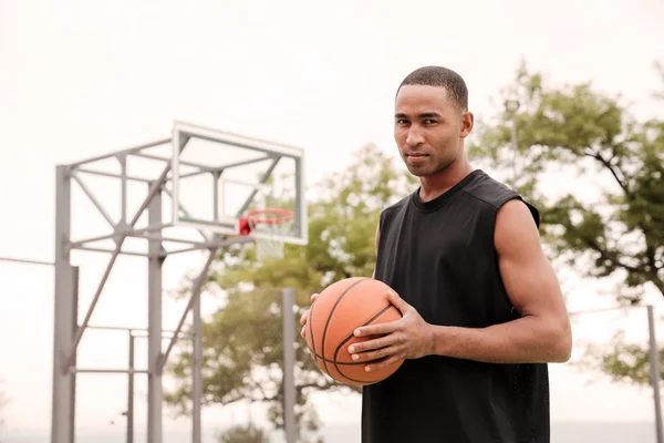 Atractivo africano jugador de baloncesto serio de pie en el str — Foto de Stock