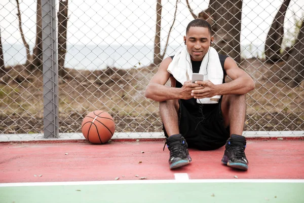 Müzik dinlemek sohbet ettiğinizi mutlu Afrika basketbol oyuncusu — Stok fotoğraf