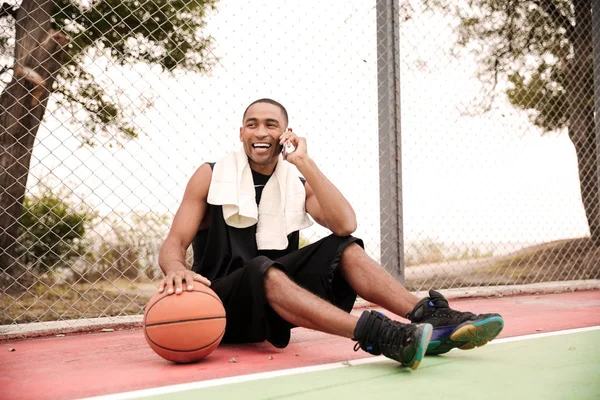 Yong african basketball player talking on his phone — Stock Photo, Image