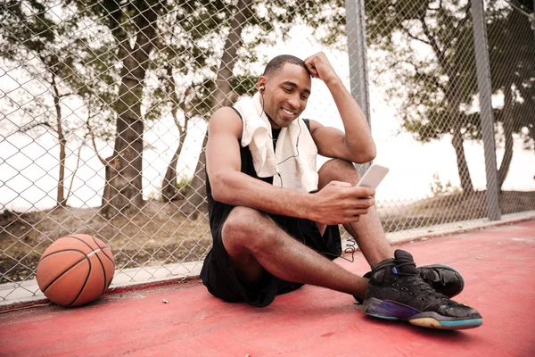 Jugador de baloncesto africano charlando y escuchando música — Foto de Stock