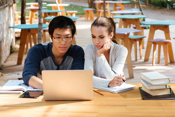 Para Uczniowie uczący się i komputera przenośnego przy stole — Zdjęcie stockowe
