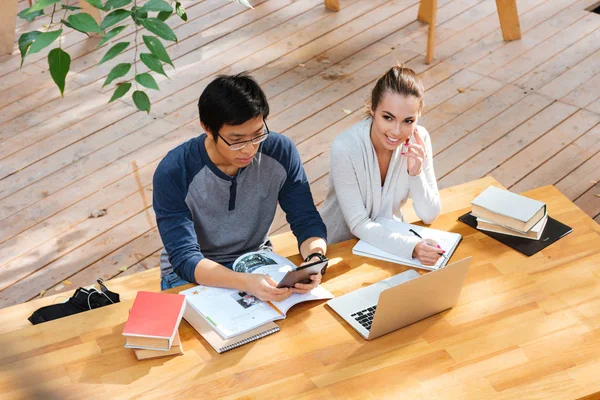 Schüler nutzen Tablet und telefonieren im Café — Stockfoto