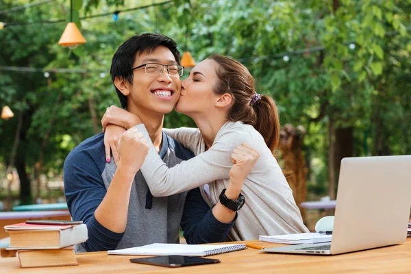 Leuke jonge vrouw kussen vrolijke Aziatische man buitenshuis — Stockfoto