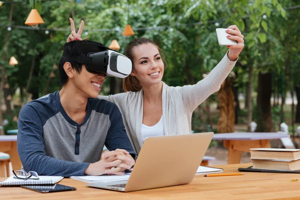 Couple using virtual reality glasses and making selfie with smartphone — Stock Photo, Image