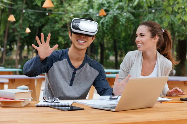 Couple using virtual reality glasses and laughing outdoors — Stock Photo, Image