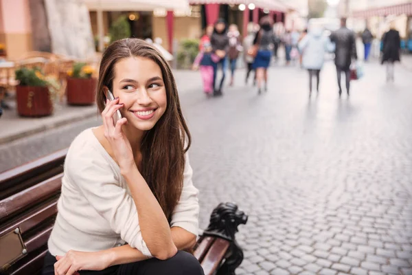 Gelukkig jonge vrouw praten op mobiele telefoon in de oude stad — Stockfoto