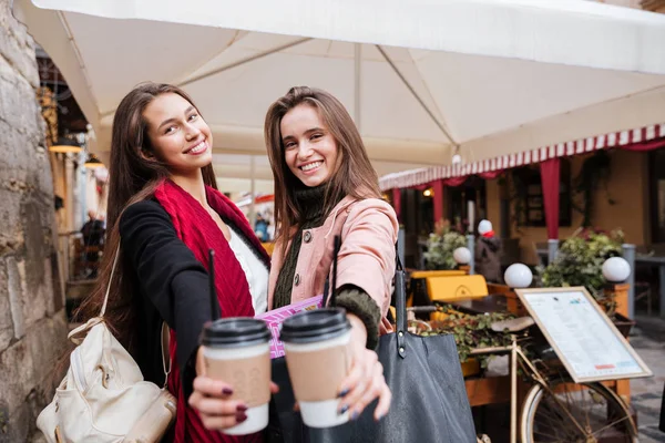 Dos jóvenes alegres sosteniendo tazas de café para llevar — Foto de Stock