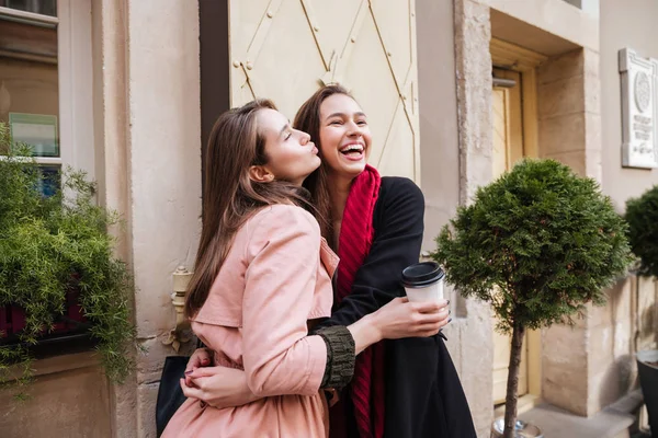 Sisters in coats are cuddling — Stock Photo, Image
