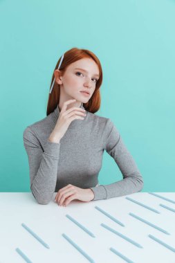 Kalem masada oturan kulağının arkasında güzel bir kadınla