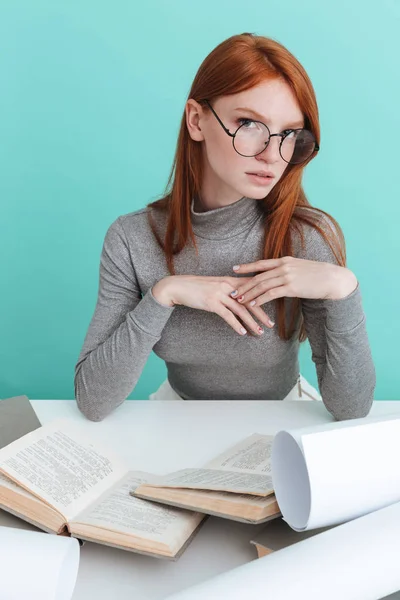 Jolie jeune femme en lunettes rondes assise et apprenant — Photo