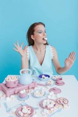Plastik sofra ve marshmallow ile oynarken oynak genç kadın