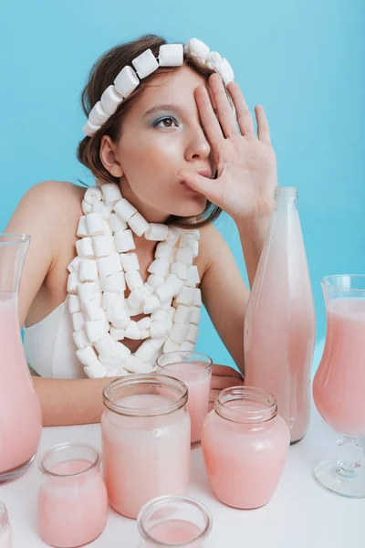 Kvinna som bär marshmallow halsband vid bordet med rosa dryck — Stockfoto