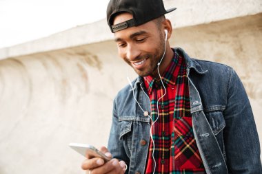 Neşeli Afrika genç adam dinleme muş sırasında telefonla sohbet