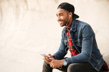 Giyen kap dinleme müzik neşeli Afrika genç adam
