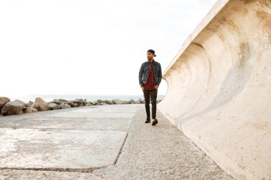 Müzik dinleme sırasında sahilde yürüyen mutlu Afrika adam