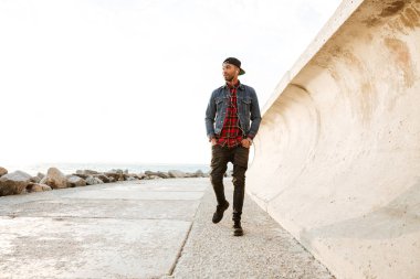 Müzik dinleme sırasında sahilde yürüyen mutlu Afrika adam