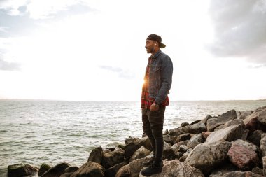 Yakışıklı Afrika adam sahilde yürüyüş ve denizde bak.