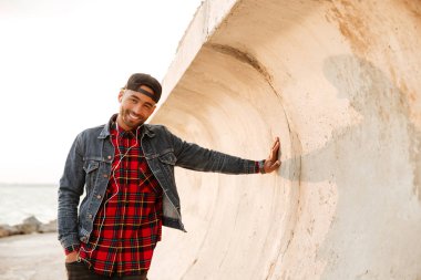 Müzik dinleme sırasında sahilde yürüyen mutlu Afrika adam