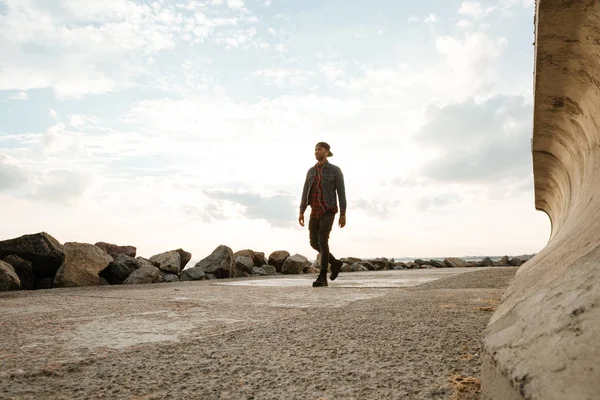 Yakışıklı genç adam sahilde yürüyüş