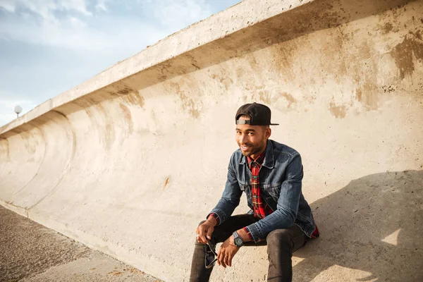 Neşeli genç adam sahilde yürüyüş şapkası