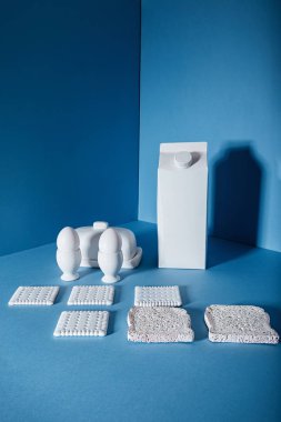 Beyaz paket süt, yumurta, tereyağı, kurabiye ve ekmek dilimleri