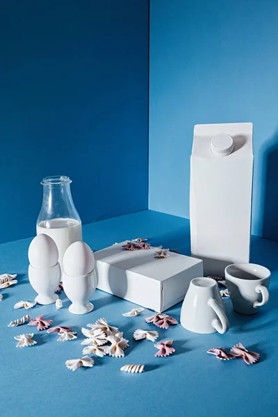 Milk bottle , two blank boxes, white coffee cups and pasta