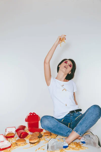 Mulher bonita comendo batatas fritas e se divertindo — Fotografia de Stock