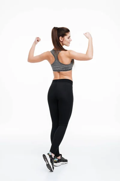 Young fitness woman standing and showing her biceps — Stock Photo, Image