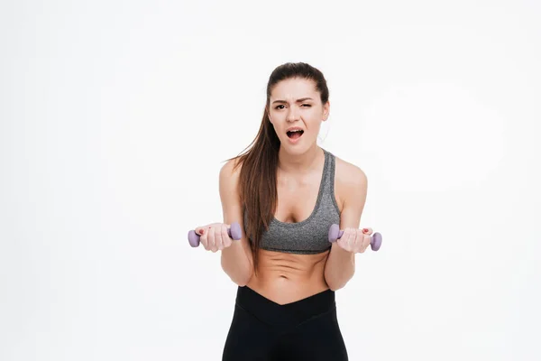 Portrait of a tired sportswoman doing intensive training with dumbbells — Stock Photo, Image
