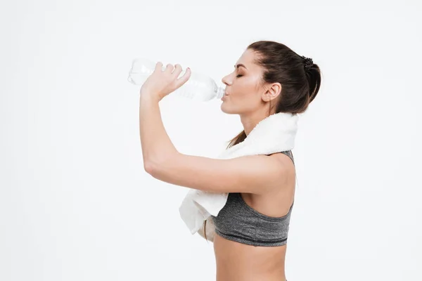 Frau trinkt Wasser aus Flasche mit Handtuch um den Hals — Stockfoto