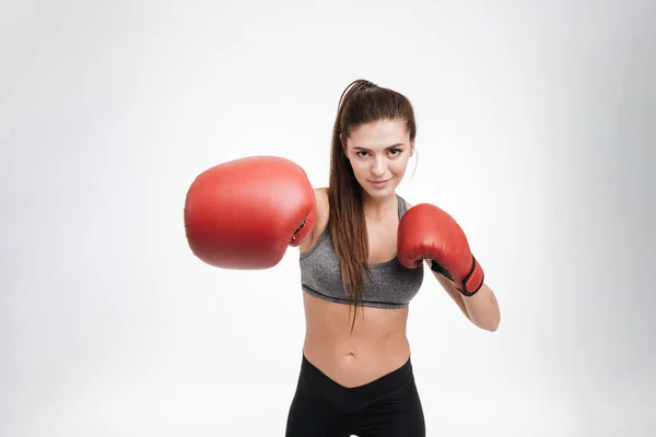 Giovane donna fitness che colpisce la fotocamera con i guanti da boxe — Foto Stock