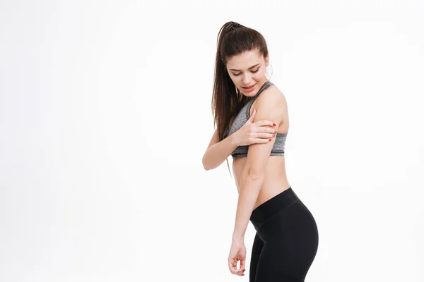 Fitness vrouw pijn houdt haar arm en op zoek weg — Stockfoto