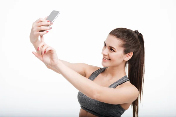 Hübsche brünette Sportlerin macht Selfie mit ihrem Handy — Stockfoto