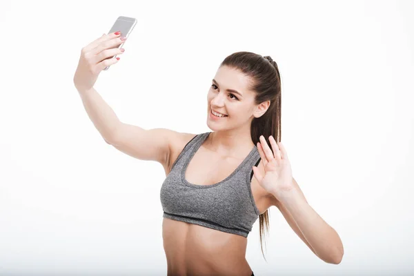 Feliz sorrindo mulher fitness acenando para seu telefone celular — Fotografia de Stock