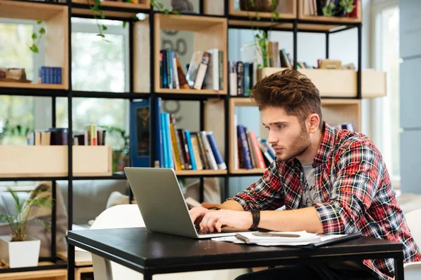 Vue latérale de l'homme avec ordinateur portable dans le bureau — Photo