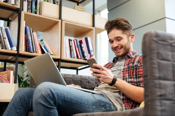 Fra under bildet av mannen som sitter på sofaen i embetet. – stockfoto