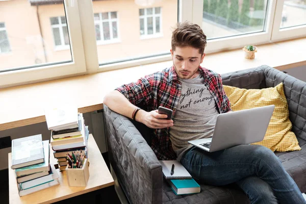 Homme surpris avec téléphone sur le canapé dans le bureau — Photo