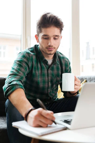 Imagen vertical del hombre con ordenador portátil en el sofá — Foto de Stock