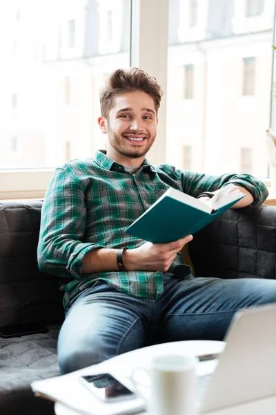 Hombre leyendo libro cerca de la mesa — Foto de Stock